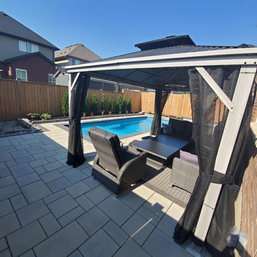 Backyard pool with covered patio seating area